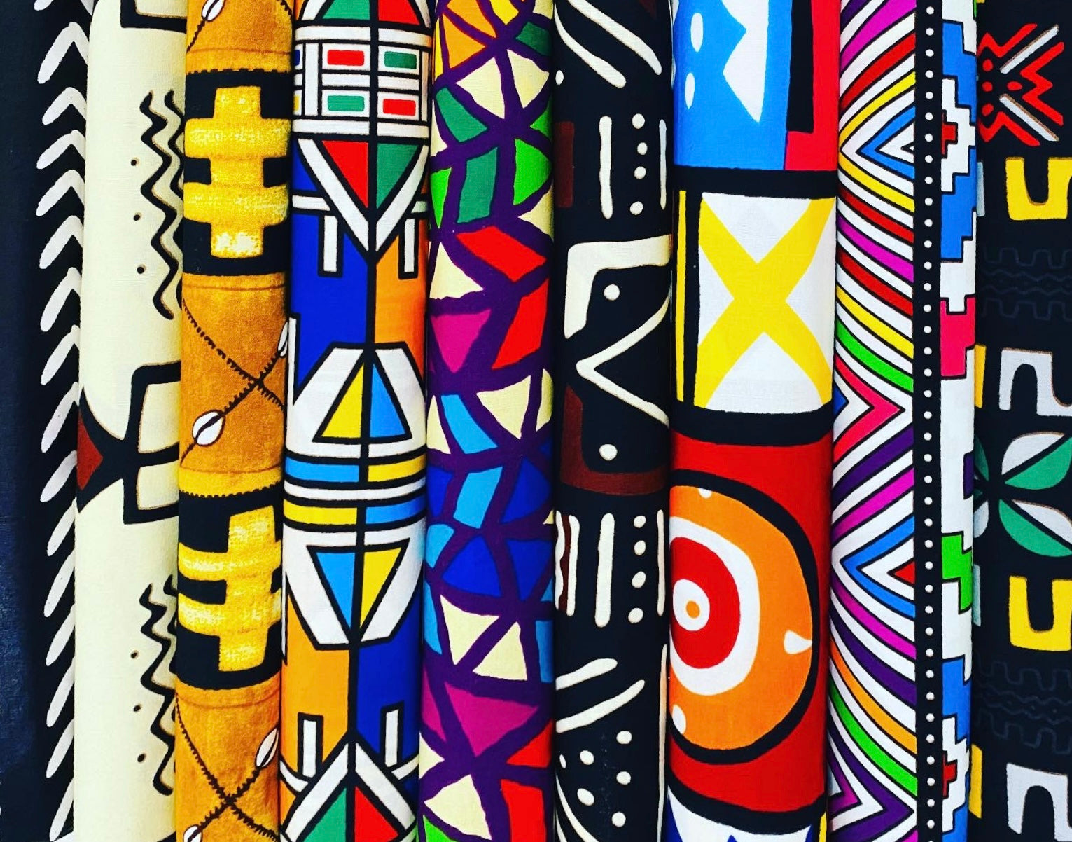 Tribal African print fabrics with bold, eclectic patterns and sun-baked palettes, available by the yard, fat quarters, and scrap bundles