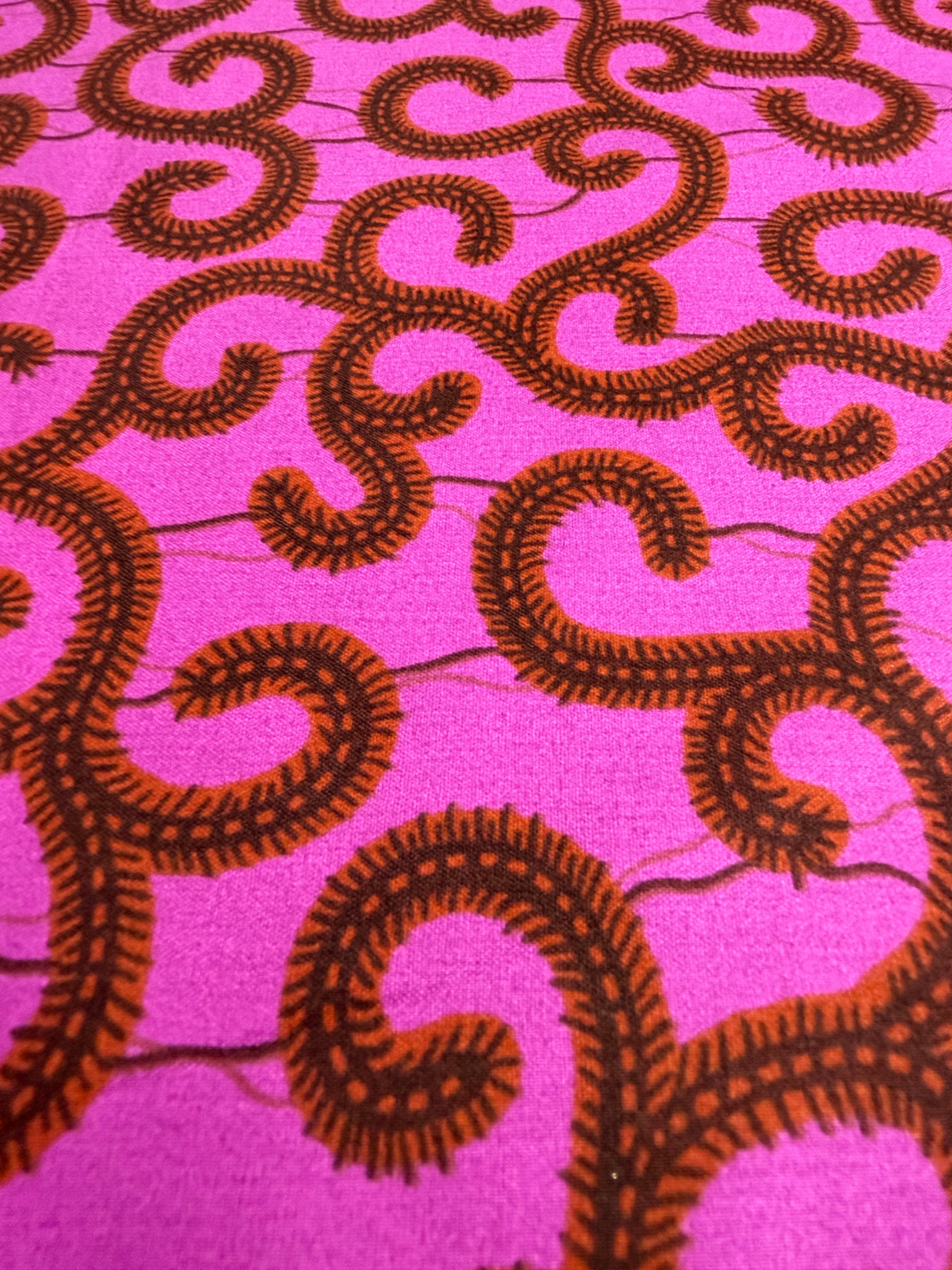 Brown spiral pattern on a pink fabric background