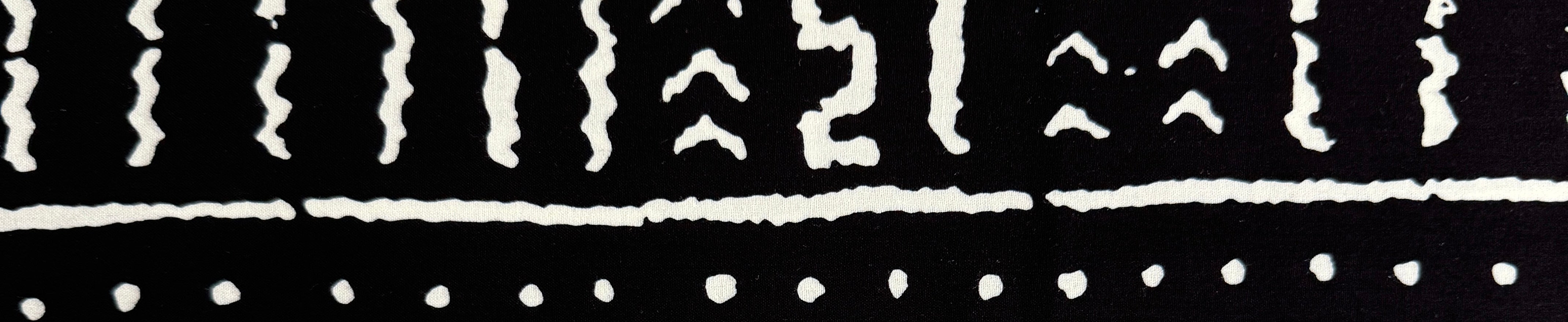 Tribal-inspired African print fabric with black and white motifs and bold, eclectic patterns