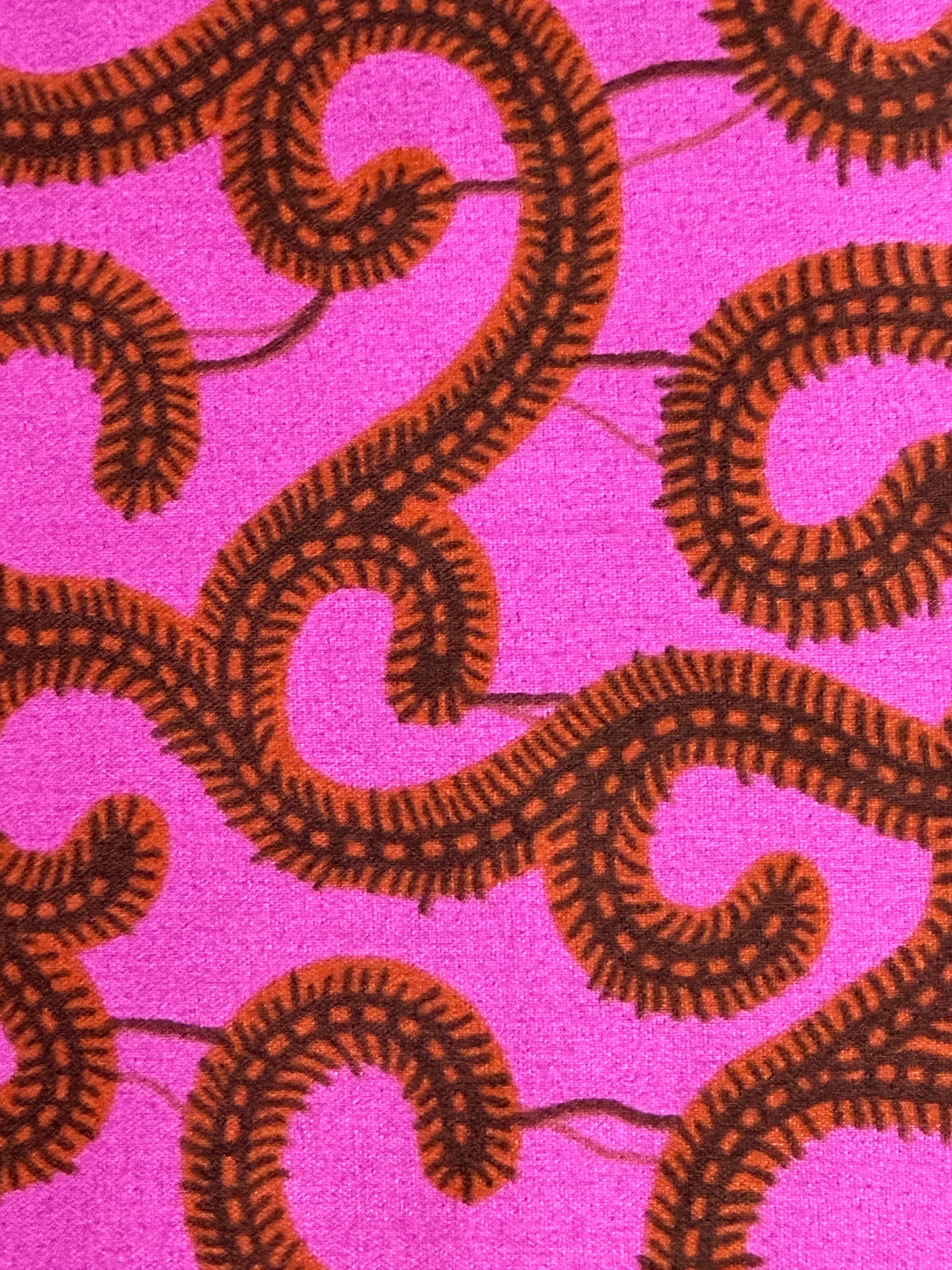 Brown wavy patterns on a pink fabric background