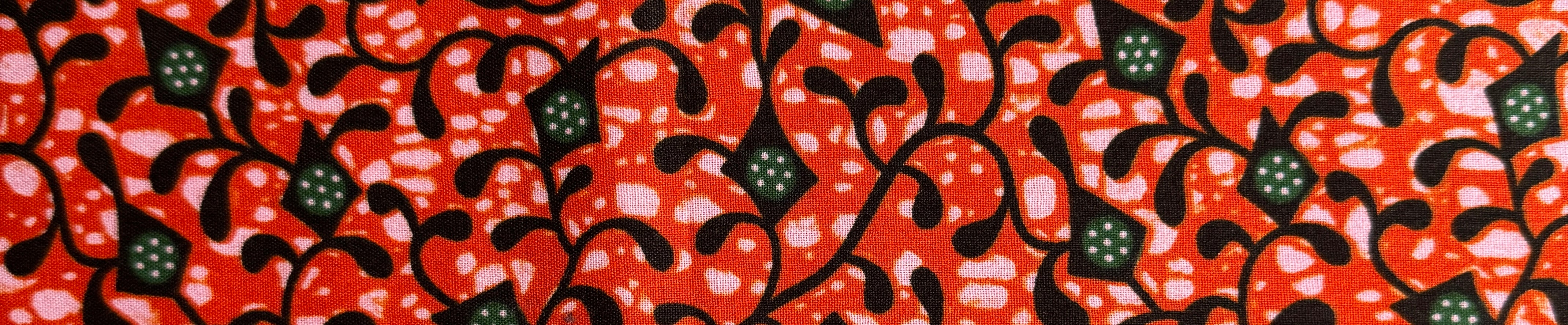 Red tonal African wax print fabric with a detailed botanical floral design and black contouring, part of the African Floral Fabrics collection.